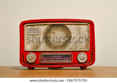 An old nostalgic red radio. Vintage radio on a table.