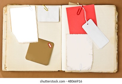 Old notebook with labels and photo frames inside over brown paper background