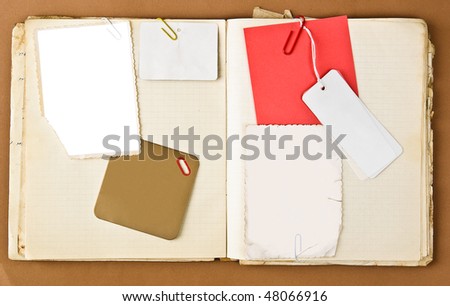Old notebook with labels and photo frames inside over brown paper background