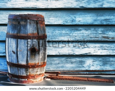 old Oak barrel in front of a painted blue wooden wall