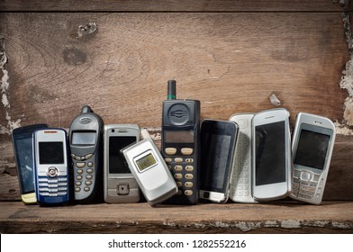 Old and obsolete mobile phone or cell phones on space of old wood background - Shutterstock ID 1282552216