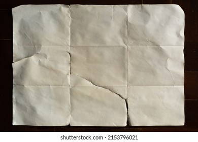 Old off white folded paper on dark wood background - Shutterstock ID 2153796021