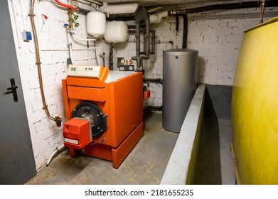 Old Oil Heating System With Oil Tank And Hot Water Tank In The Basement Of A Family House - Heating With Fossil Fuels