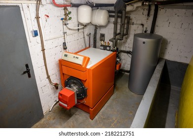 Old Oil Heating System With Oil Tank And Hot Water Tank In The Basement Of A Family House - Heating With Fossil Fuels