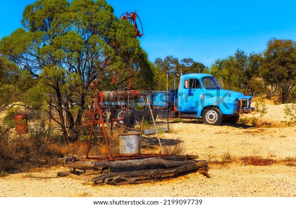 Old open mine\
shaft well and rust ute truck in Lightning ridge opal mining town\
of NSW outback, Australia.