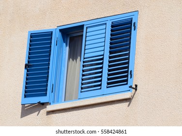 Old opened window and shutters painted with blue color, traditional Cyprus mediterranean style