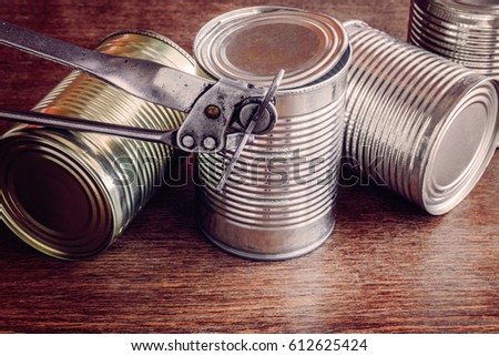 Old opener open to metallic can on the table in the kitchen. Canned food. Condensed milk. Healthy eating and lifestyle.