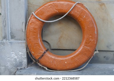 Old Orange Lifebuoy On Wall Background