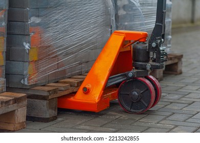 Old orange manual hand pallet trucks. Close up wheel of hydraulic hand pallet truck. - Powered by Shutterstock