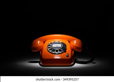 Old Orange Retro Phone On Black Background