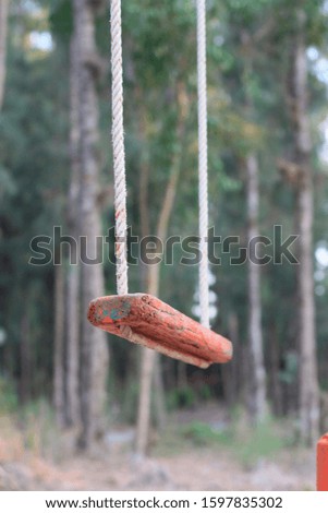 old orange wooden swing in playground.