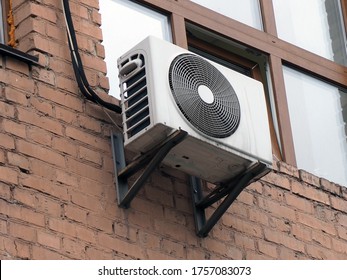 Old Outdoor Air Conditioning Unit On The Facade Of A Brick House
