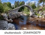 The old packhorse bridge over the River Dulnain built from cut stone in the town of Carrbridge in the north east of Scotland