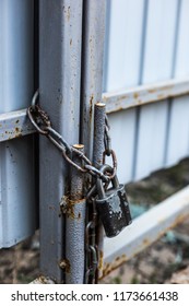 Old Padlock And Chain On The Gate.