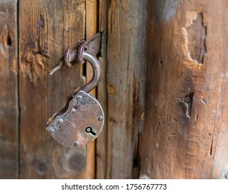 
Old Padlock Open Rusty On A Light Brown Wooden Wall