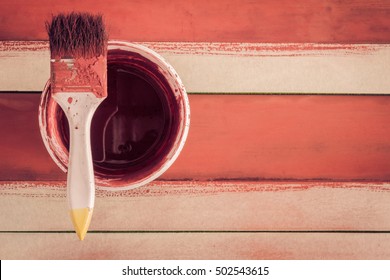 Old Paint Brush on Paint Can and Painting Wall Background with Vintage Tone Lighting , Top view ,Paint Bucket on Old Wood.