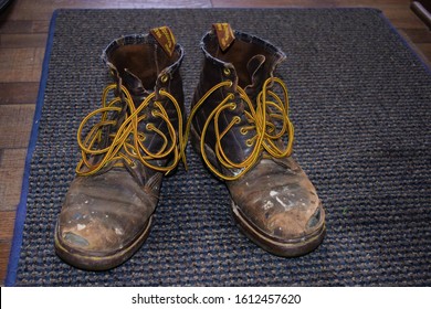 Old Pair Of Leather Work Boots With The Shoelaces Undone