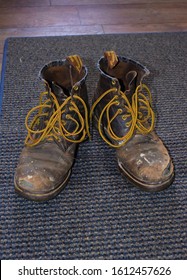 Old Pair Of Leather Work Boots With The Shoelaces Undone