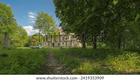 The old palace of a magnate family stands in the middle of a park on a spring May afternoon.A beautiful spring May day at the peak of spring development under a blue sky in an old park.