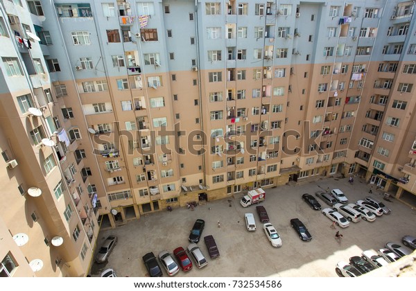 Old panel house. A view of the serial high-rise\
apartment buildings in Baku suburbs with the view of the parking\
lot underneath it.