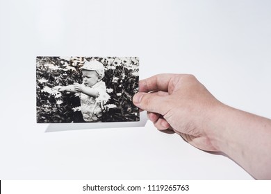 Old Paper Photo In Mans Hands. Abstract Photo Of Childhood.