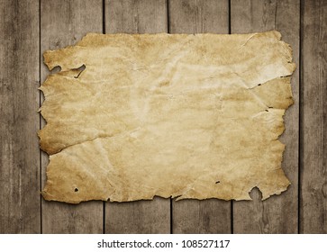 Old paper sheet at grunge wooden background with copy space