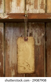 old paper tag with string hanged on on hook in old  wooden cupboard, shallow DOF