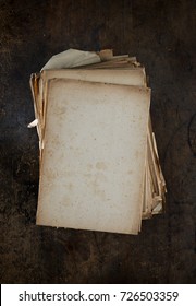 Old Papers Stacked On A Old Grungy Wooden Desk. Top View. Low Key