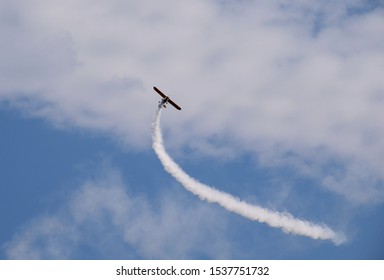 An Old Passenger Plane Flying Dynamically Through The Cloudy Summer Sky While At The Same Generating A Line Of Smoke Or Fumes Seen During A Cloudy Yet Warm Summer Day In Poland During A Hike