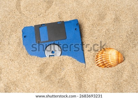 Old pc floppy disk in sand