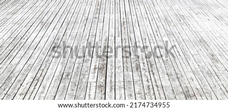 An old peeled wooden pavement painted in white in a sunny day. Photo in perspective with selective focus