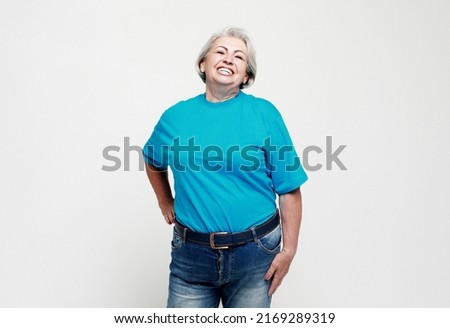 Old people and lifestyle concept: Portrait of a happy senior woman wearing blue tshirt isolated on white background