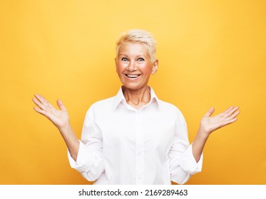 Old People, Modern Lifestyle, Body Language Concept. Close-up Portrait Of Shocked Mature Woman With Short White Hair, Looking At Camera, Isolated On Yellow Background