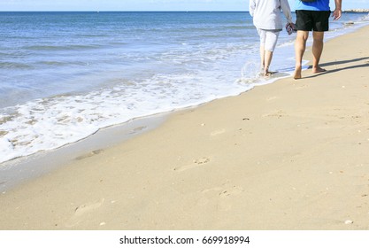 Old People Taking A Walk On The Beach