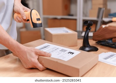 Old person is applying a product label to a brown box with a barcode. An elderly man is starting to sell products online. - Powered by Shutterstock