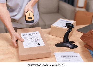 Old person is applying a product label to a brown box with a barcode. An elderly man is starting to sell products online. - Powered by Shutterstock