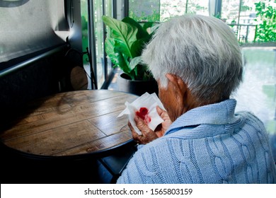 Old Person Coughing Blood Covering Mouth With A Tissue. She Has Flu, Allergy Symptoms, Acute Bronchitis, Pulmonary Infections Or Pneumonia. Concept: Respiratory Infections And Healthcare.