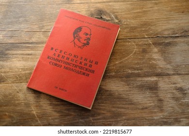 old personal document on wooden table, red Komsomol card, political youth organization, citizen of USSR middle of twentieth century, family archive, Inscription 