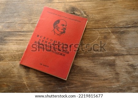 old personal document on wooden table, red Komsomol card, political youth organization, citizen of USSR middle of twentieth century, family archive, Inscription 