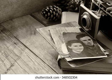 Old Photo Camera, Antique Photos And Old Book On Wooden Table. Black And White. Selective Focus