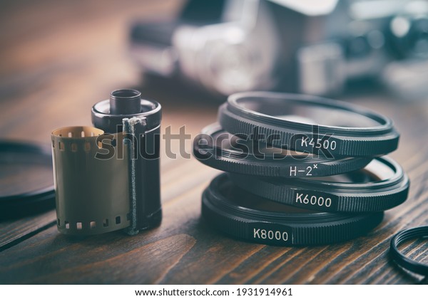 Old photo film cassette, photo filters,\
vintage camera on background, selective focus.\
