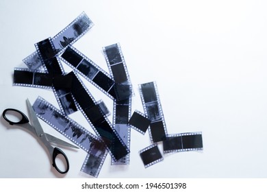 OLD PHOTO NEGATIVES AND BLACK SCISSORS ON WHITE BACKGROUND