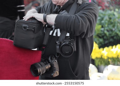 old photographer outdoor in hoodie with 2 two brandless cameras hanging on neck. no face. near standing near twins girls. pair of modern mirrorless digital photo cameras. - Powered by Shutterstock