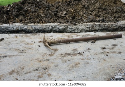 Old Pick Axe Placed On A Concrete Floor Surface After Digging For Drainage.