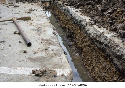 Old Pick Axe Placed On A Concrete Floor Surface After Digging For Drainage.