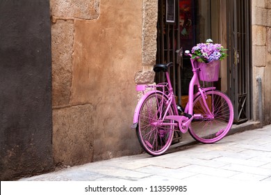 an old pink bike standing on the street