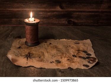 Old Pirate Map On Stone Table, Ancient Candle, Many Different Coins, Map Of Treasures