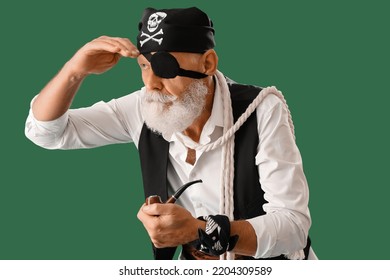 Old pirate with smoking pipe and with rope on green background