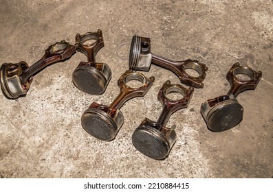 Old piston group with connecting rods on the floor in the garage. Car repair. - Shutterstock ID 2210884415