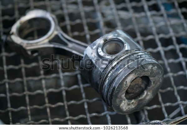 Old pistons and\
connecting rods, main parts for an internal combustion engine.\
at\
garage - spare parts. 